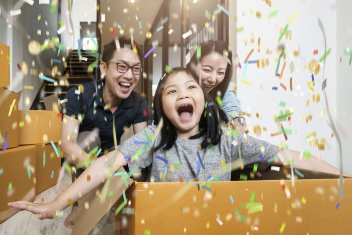 happiness asian family mom dad daughter moving in new house hand carry box of stuff with exited and fun cheerful expression